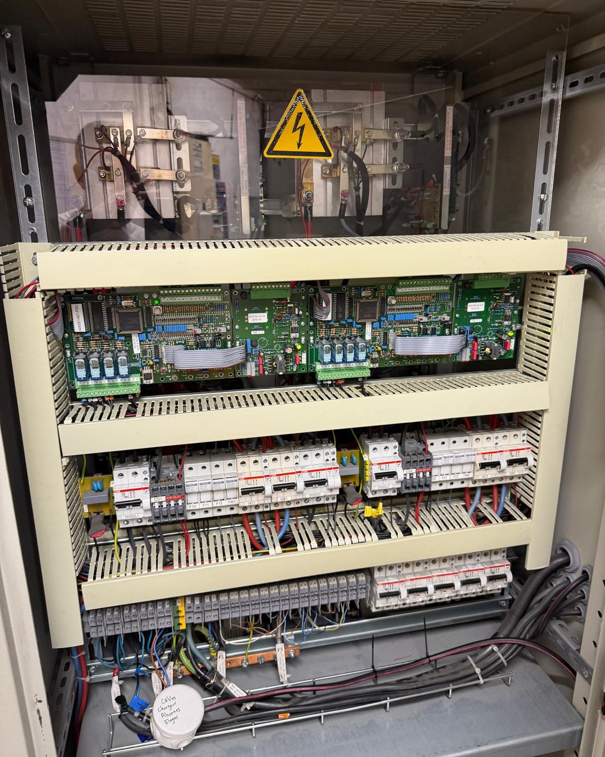 Armoire de chargeurs ouverte : cartes de contrôle, disjoncteurs et borniers