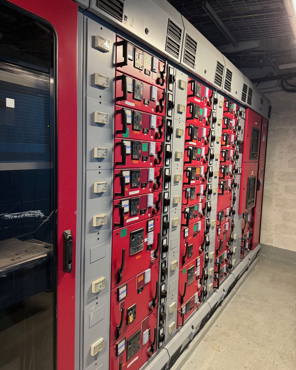 Allée de tableaux électriques rouges dans un local technique