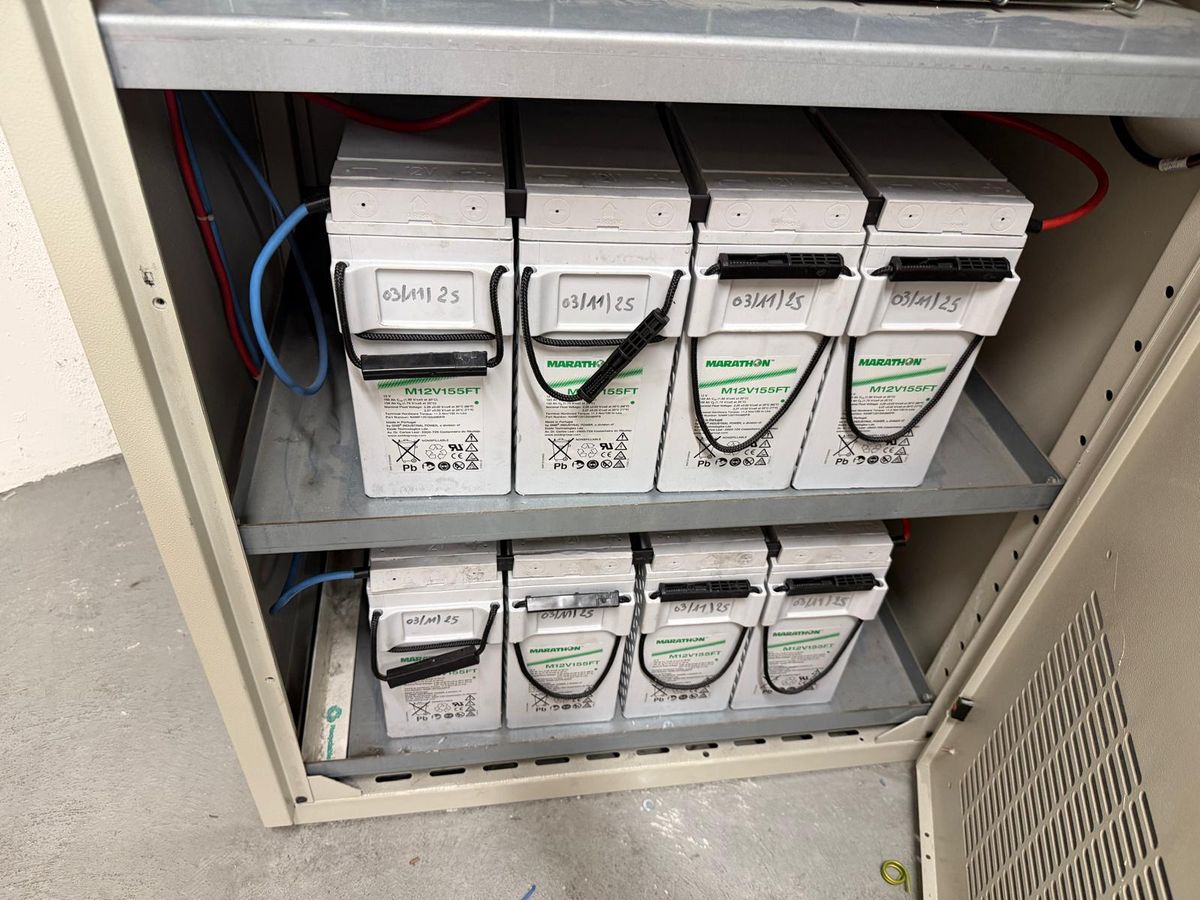 Batteries de secours sur étagères dans une armoire